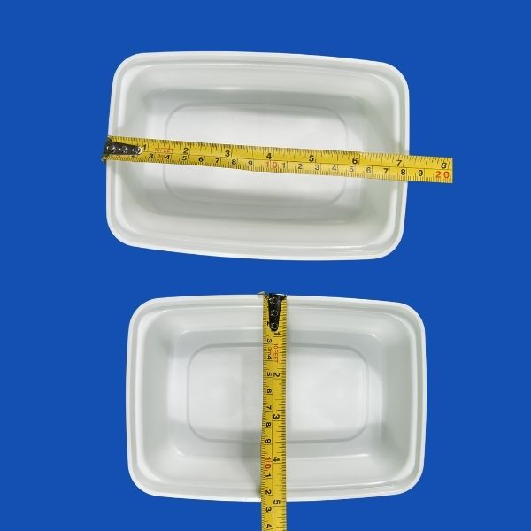 A single white rectangular plastic food container with its matching clear lid, shown slightly open, against a white background